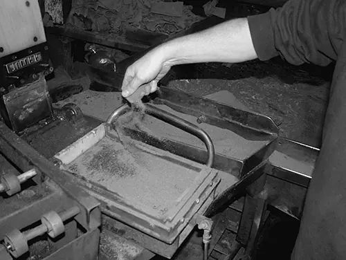 Sand being thrown into a tile mould
